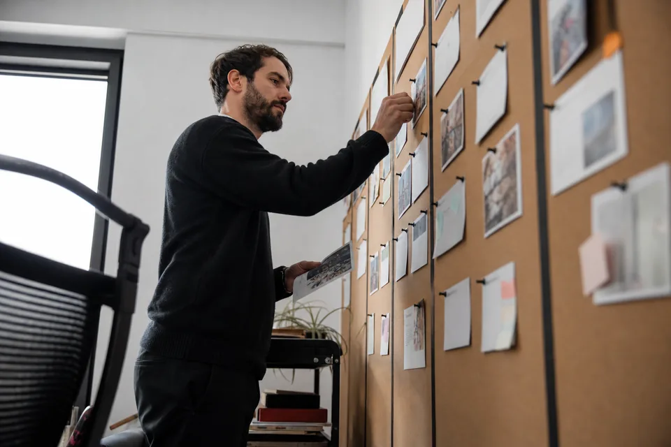 Marketing lead moving approved review cards on a large kanban board with columns for new, approved and hidden