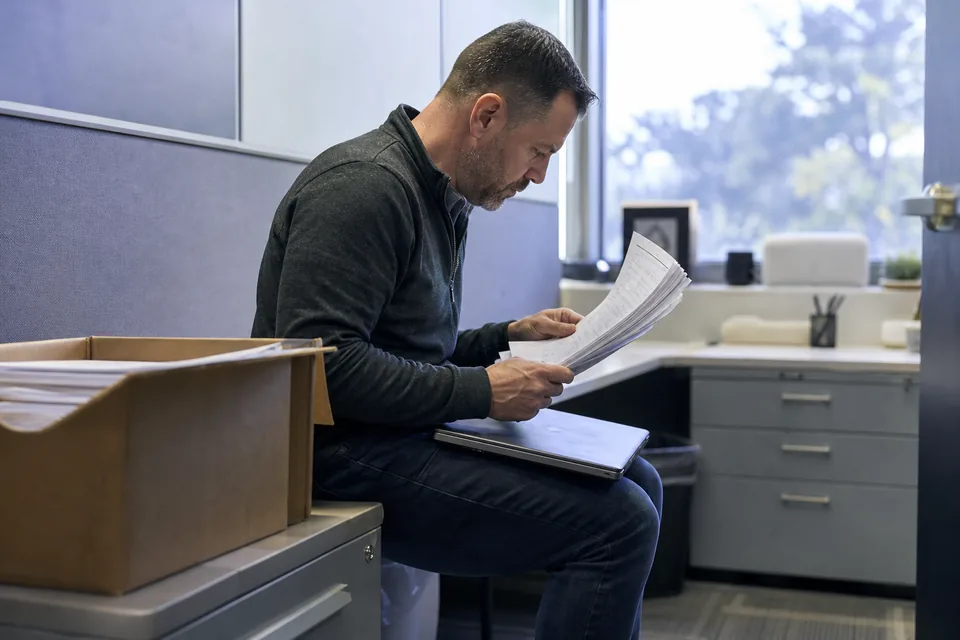 Customer success specialist reading through a stack of returned feedback forms with handwritten answers